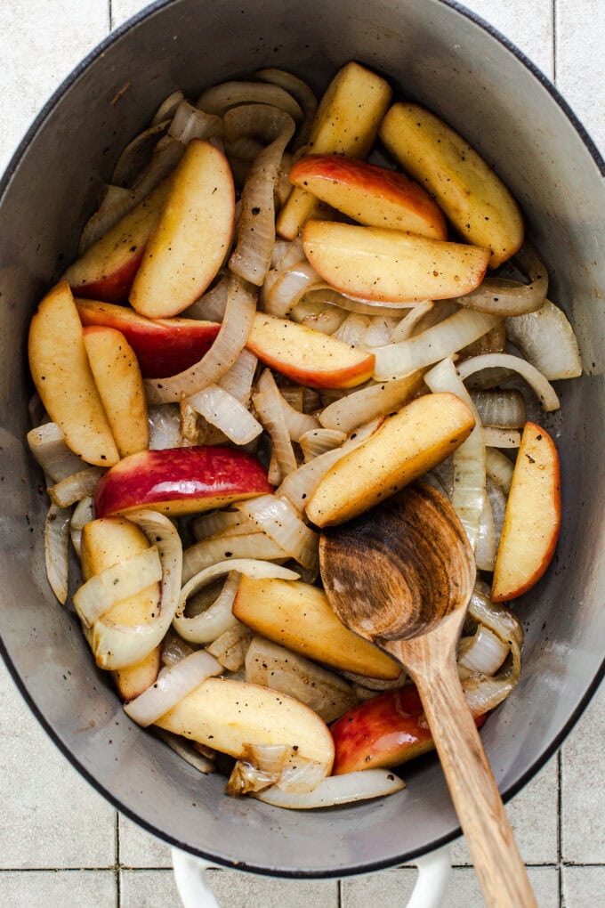 apples and onion in large pot with wooden spoon
