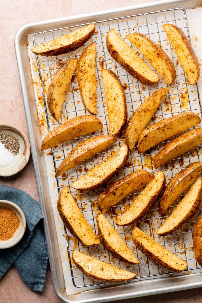 seasoned potato wedges on rimmed baking sheet