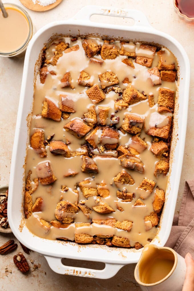 maple rum sauce poured over bread pudding in baking dish