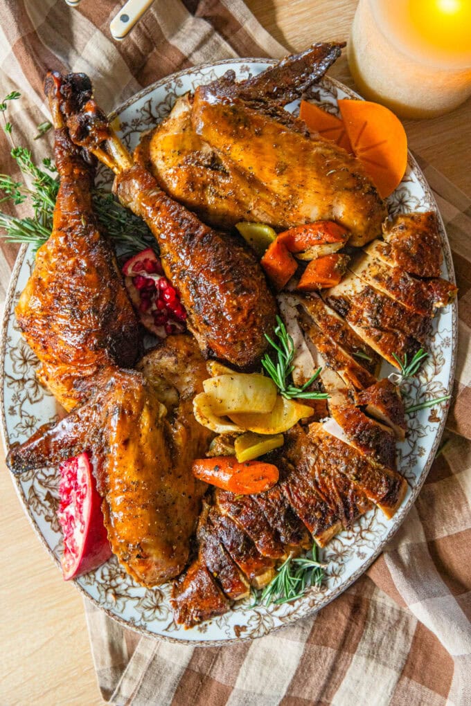 cajun butter turkey parts on platter with fresh herbs