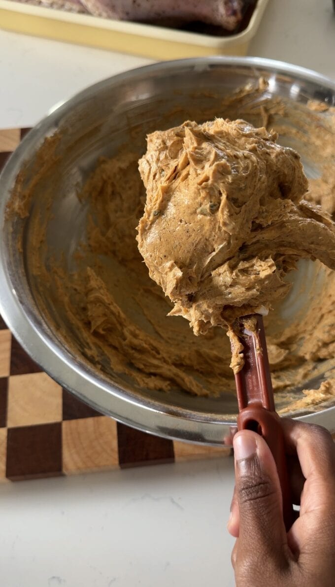 black hand holding spatula with cajun compound butter