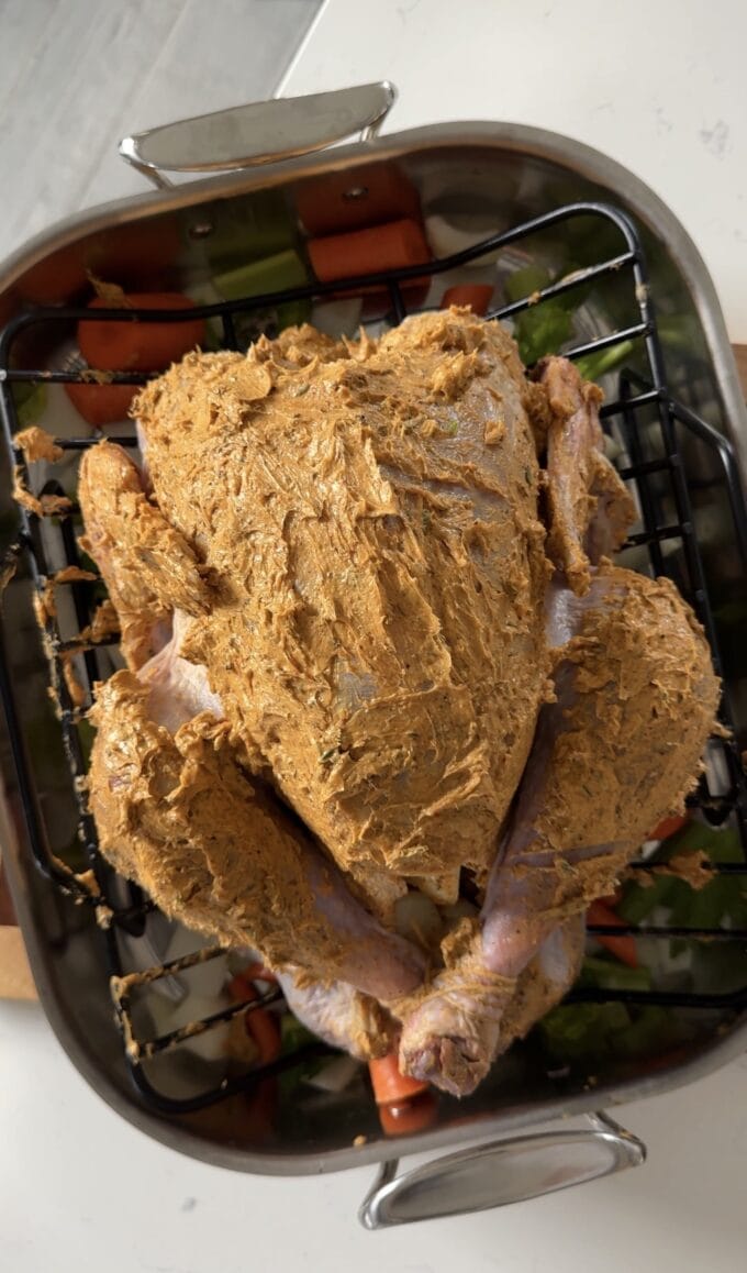 turkey slathered with cajun compound butter in roasting pan