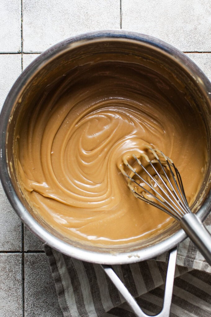 caramel icing in saucepan with whisk