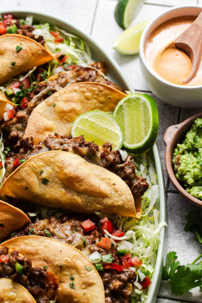 crispy ground beef tacos on platter with lettuce