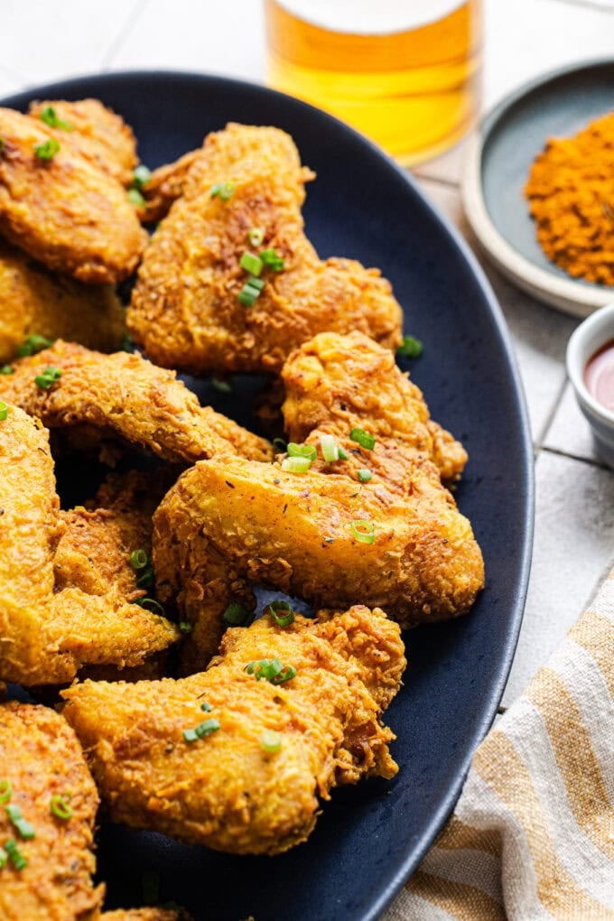 jamaican curry chicken wings with sliced scallions on platter