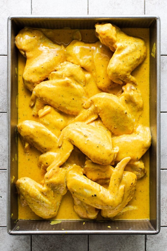 whole wings in marinade in baking pan