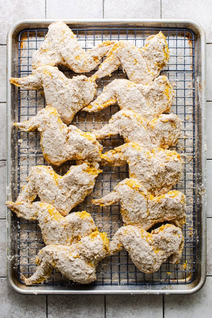 raw chicken wings coated in flour on wire rack