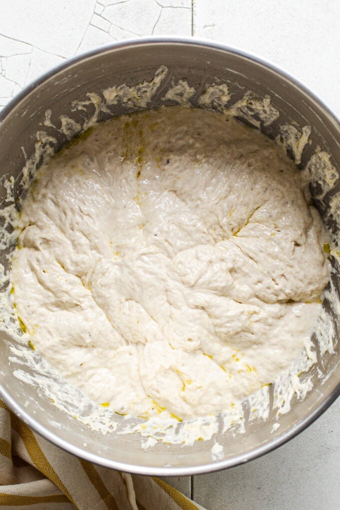 proofed focaccia dough in steel bowl