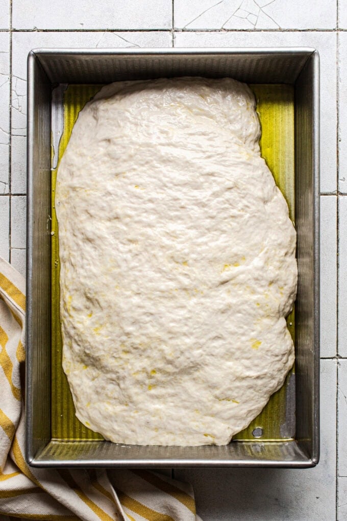 focaccia dough in baking pan with oil