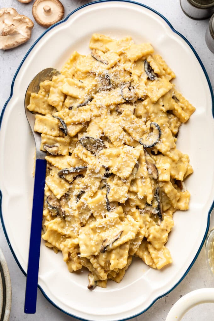 creamy miso mushroom pasta on white platter with blue spoon