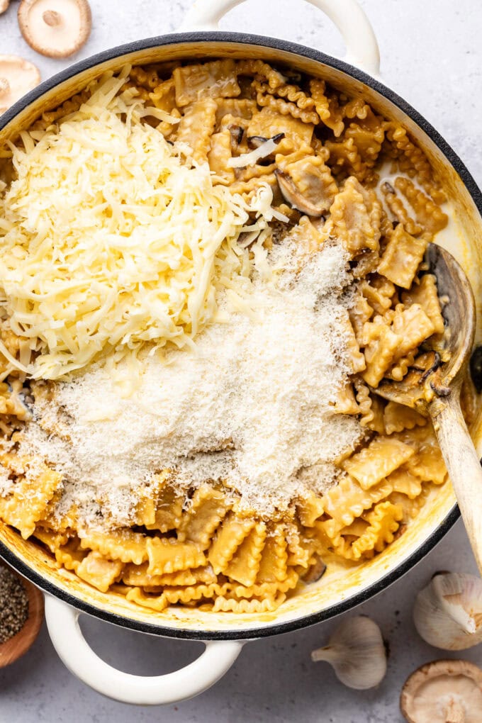 shredded cheese on top of pasta in pot