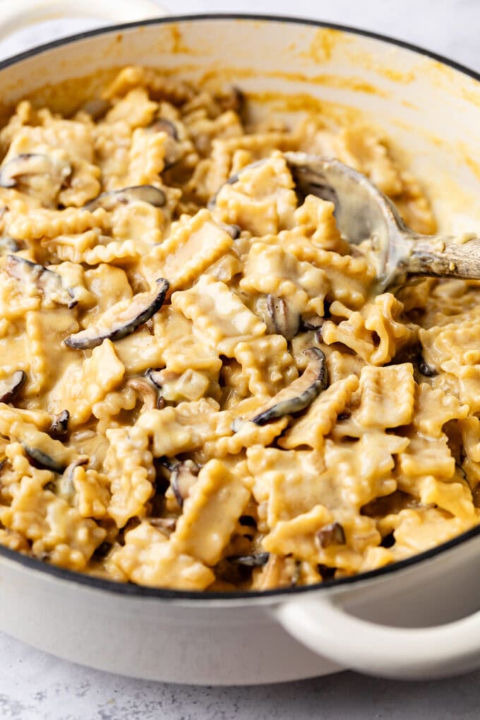 creamy miso mushroom pasta in pot with wooden spoon