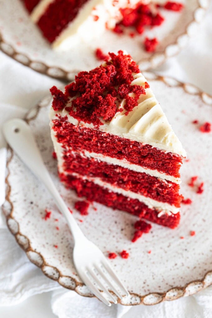 slice of red velvet cake on small plate with white fork