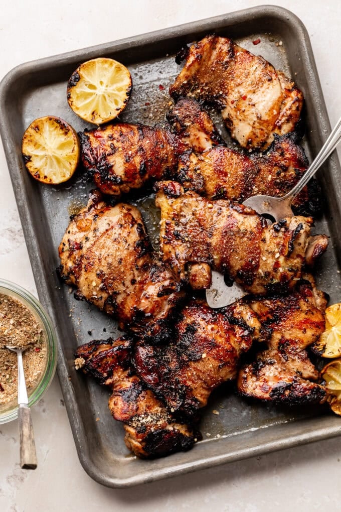 grilled jerk chicken thighs on small baking tray