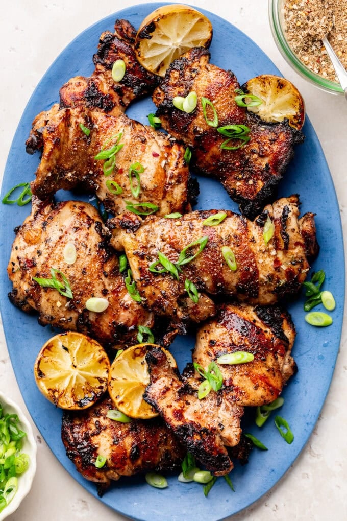 grilled jerk chicken thighs on blue oval platter