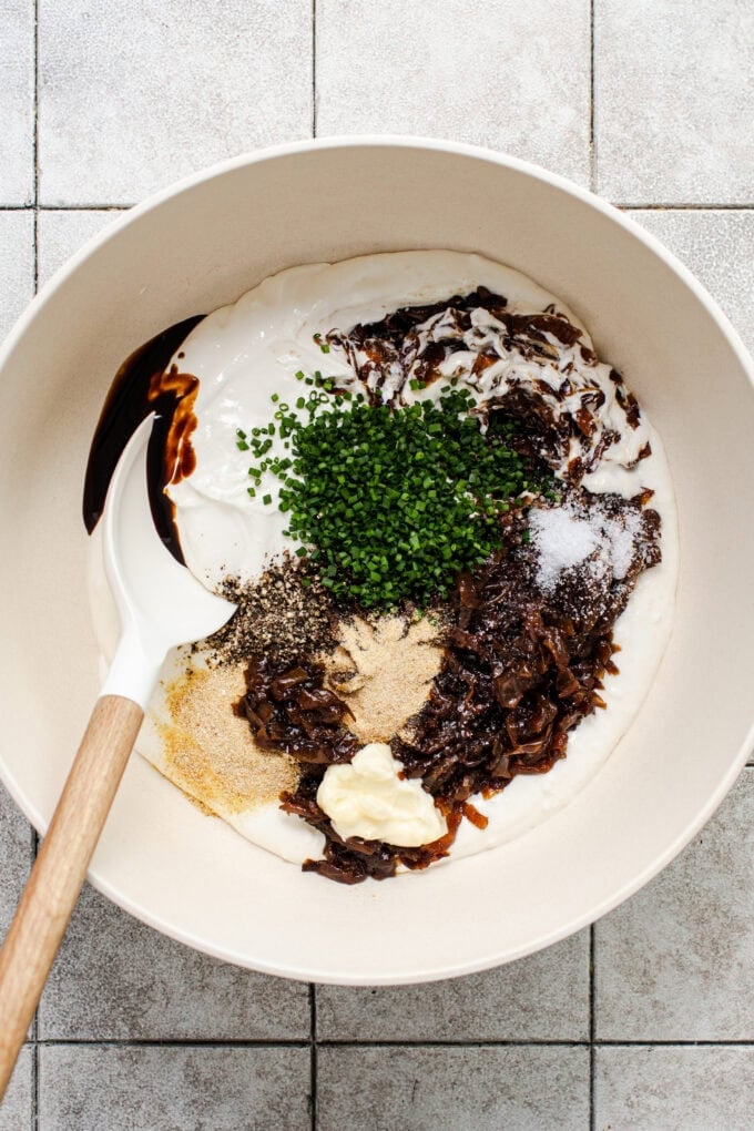 ingredients for caramelized onion dip in bowl with spoon