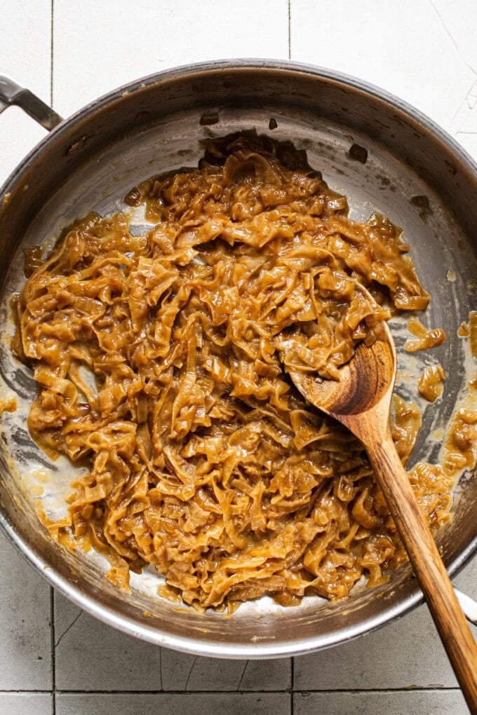 caramelized onions in pot with wooden spoon