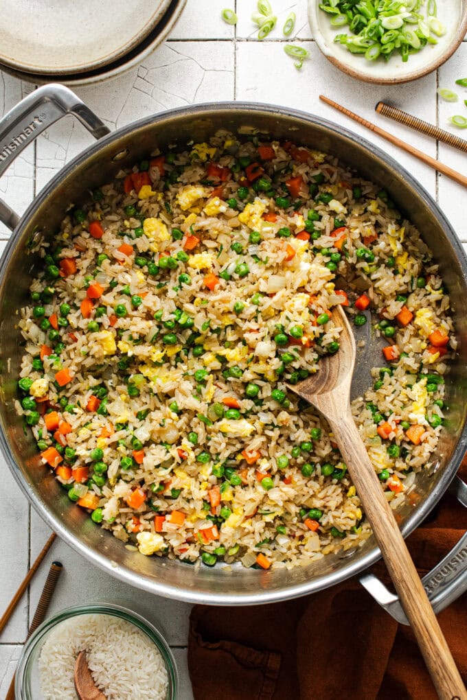 fried rice in pan with wooden spoon