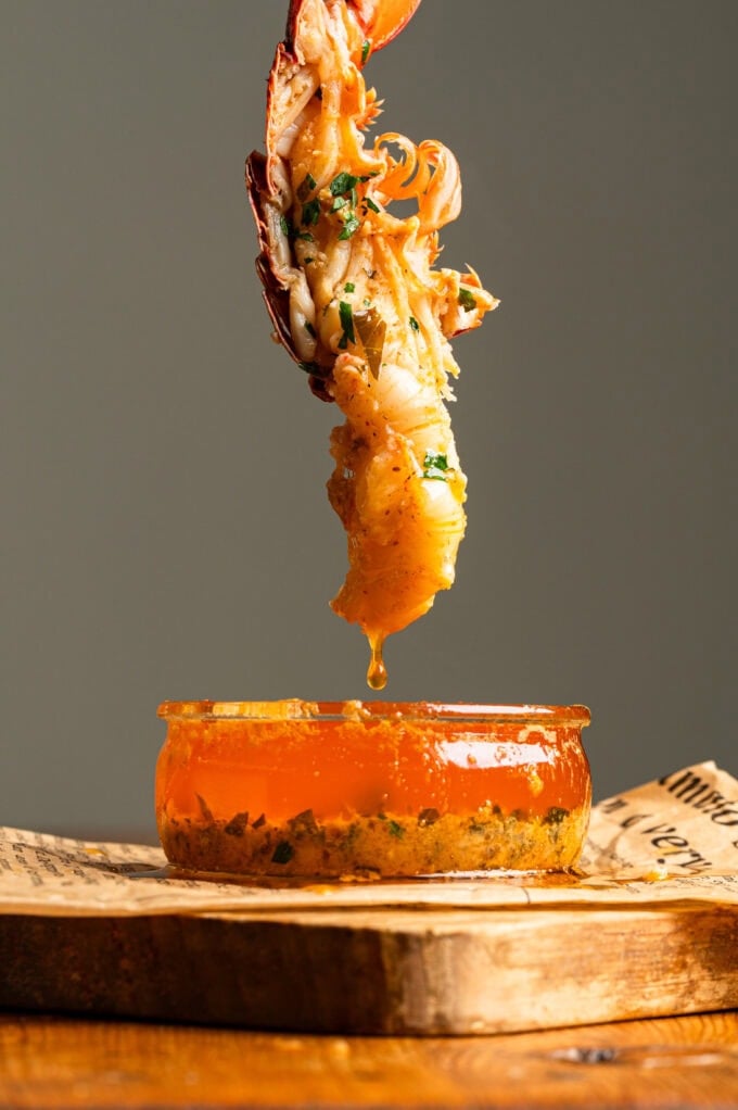 lobster being dipped into garlic butter sauce