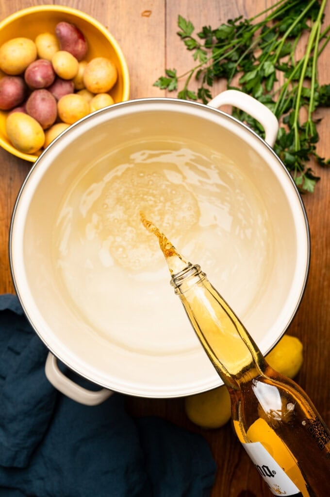 bottle of beer being poured into pot of water