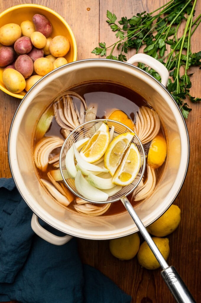 pot of water with slices lemons and onion