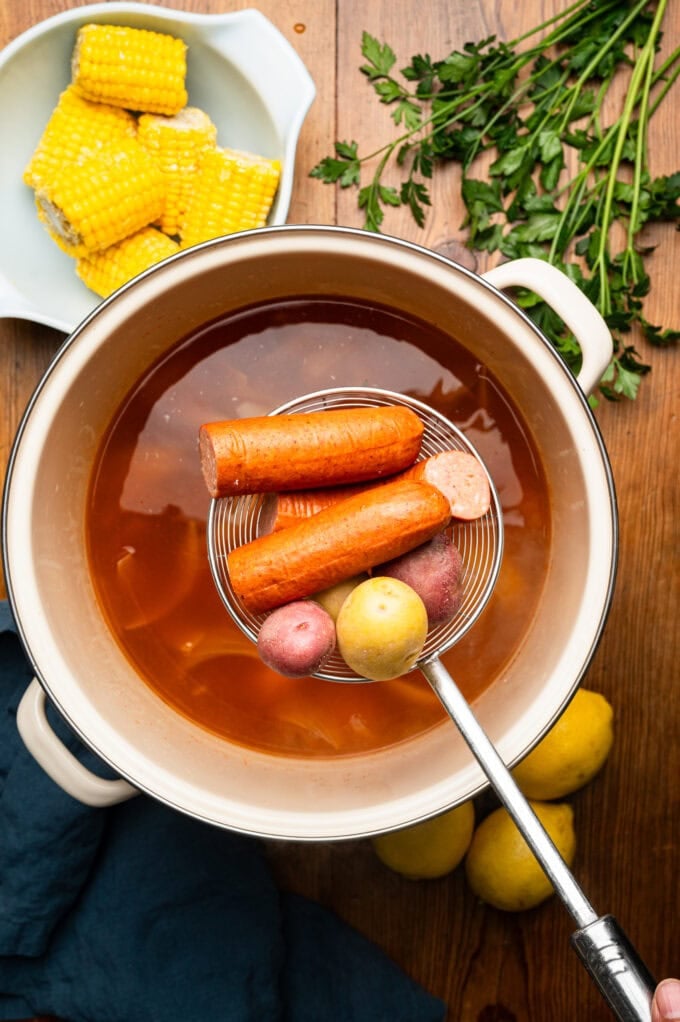 sausage and potatoes being added into boil