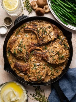 smothered pork chops with mushroom gravy in skillet
