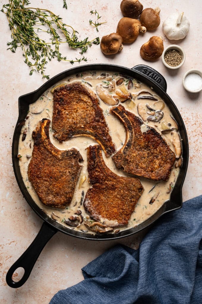browned pork chops in skillet with mushroom gravy