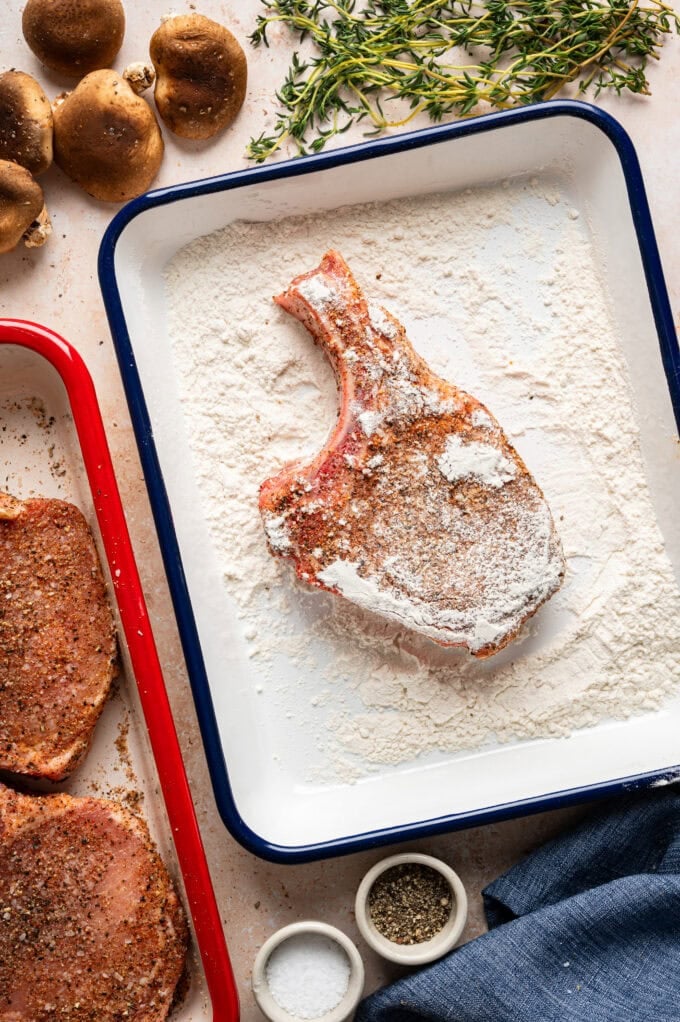 seasoned, floured pork chops in baking dish