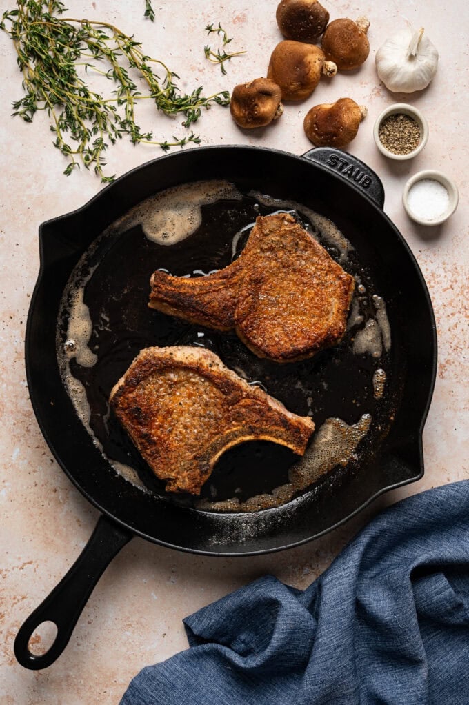 pork chops searing in skillet