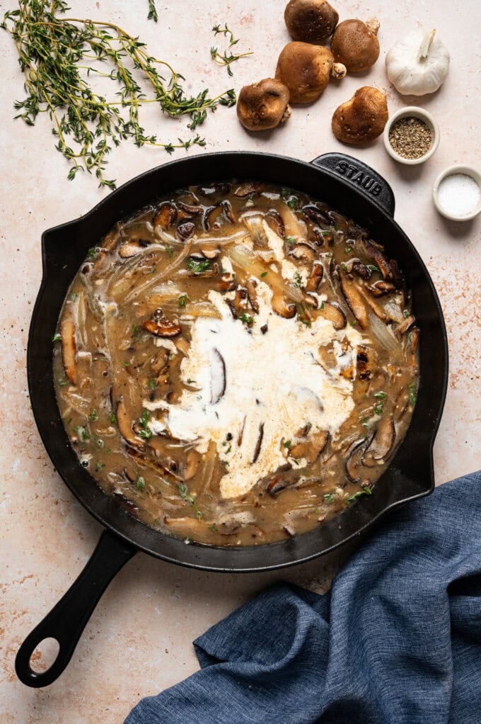 cream and broth in skillet with mushrooms