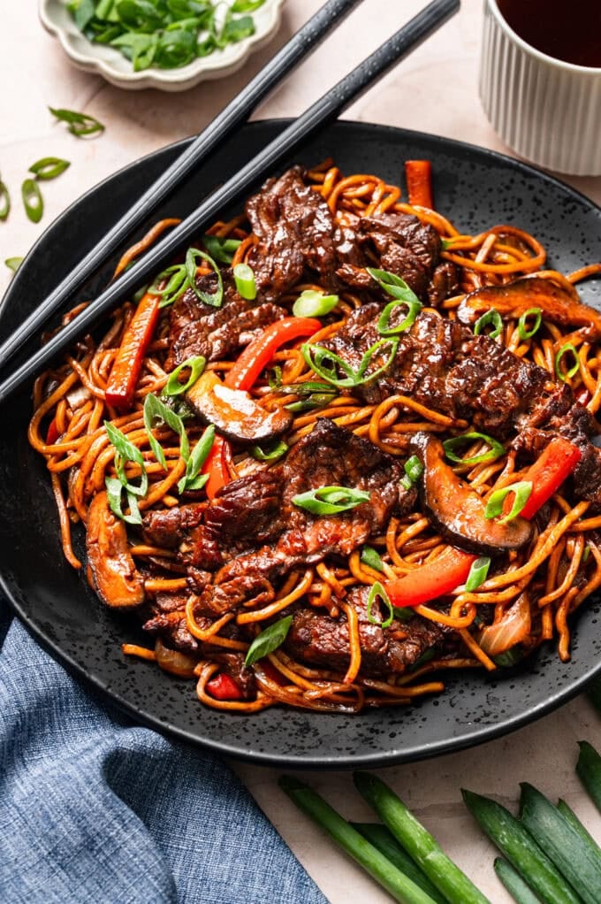 steak lo mein in black bowl with chopsticks