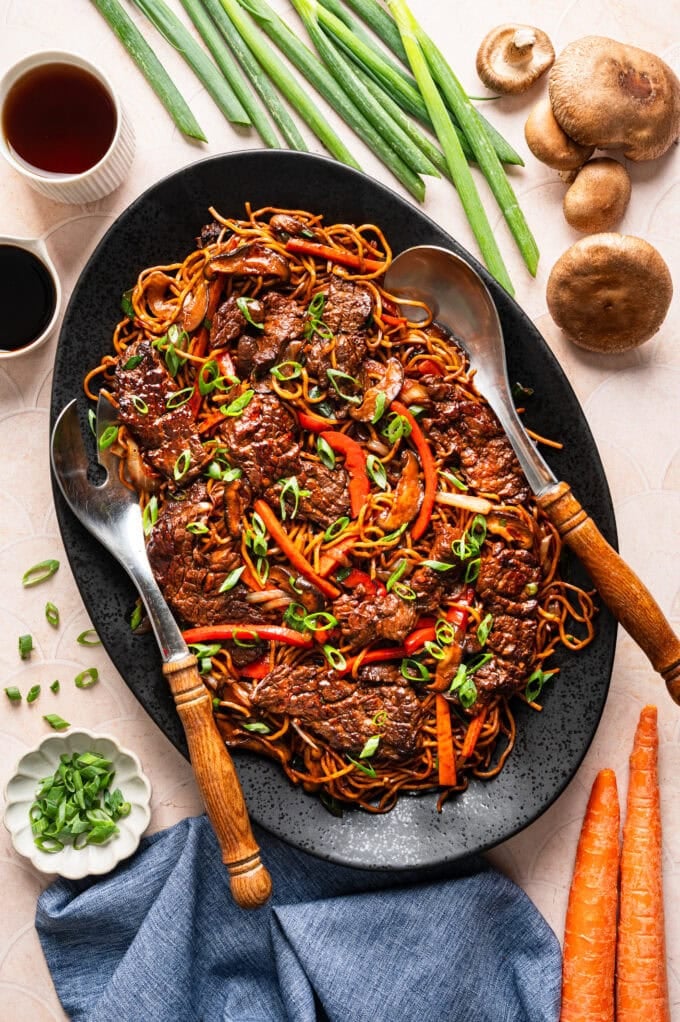 steak lo mein on oval platter with utensils