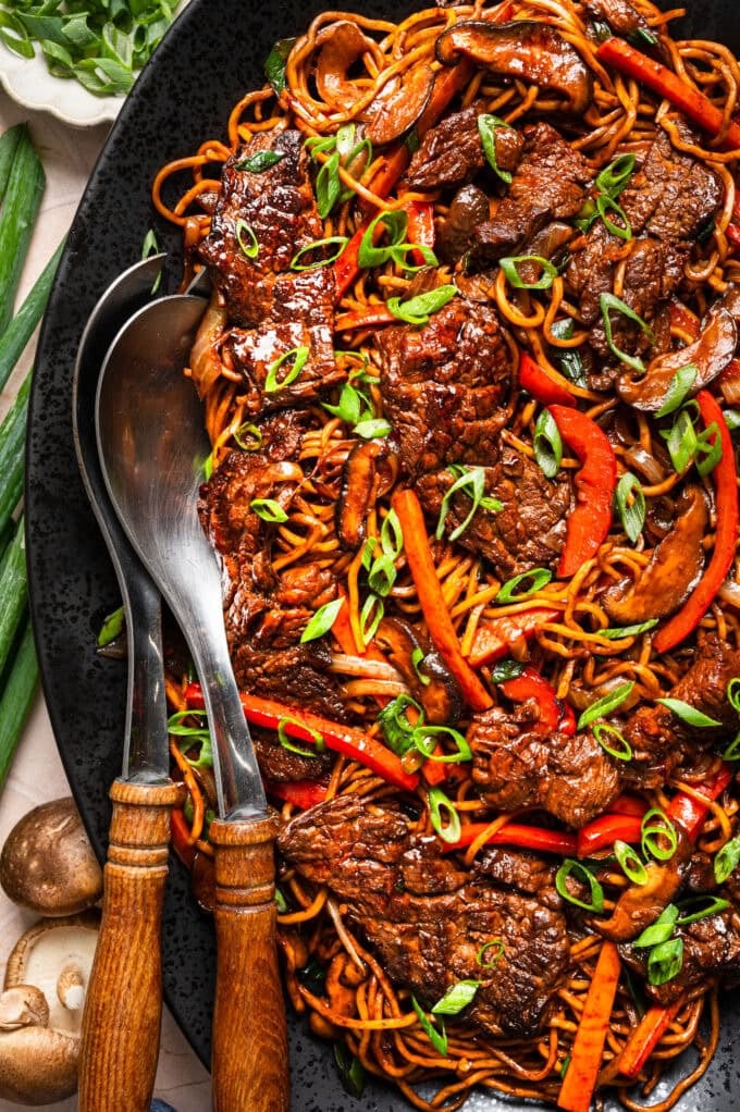 closeup of beef lo mein on black platter