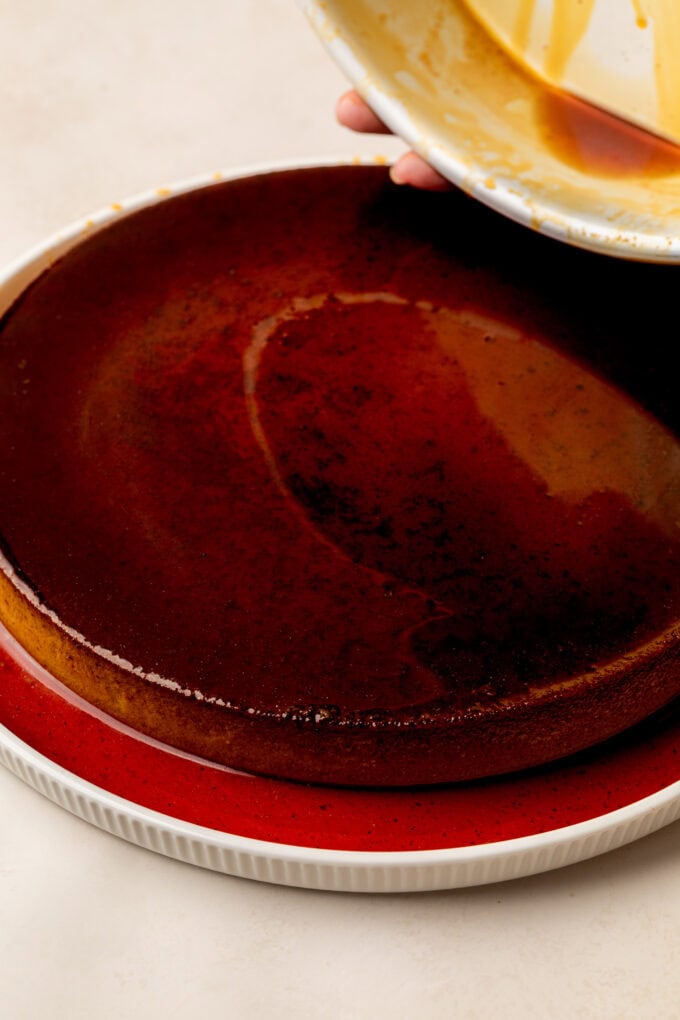 hand removing flan from cake pan