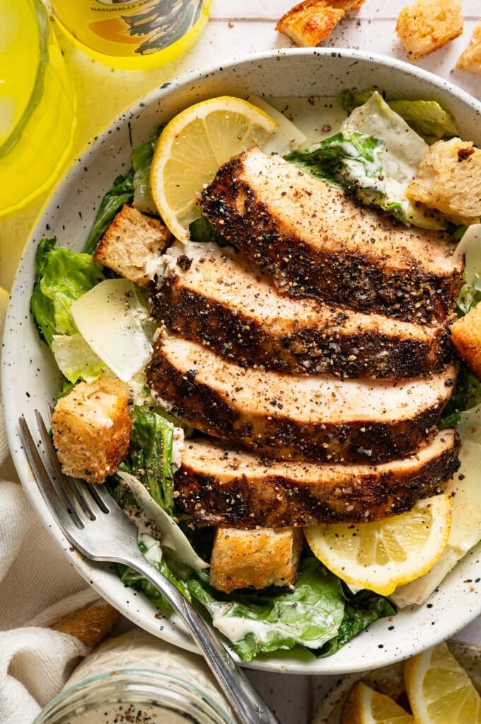 jerk chicken caesar salad in bowl with fork