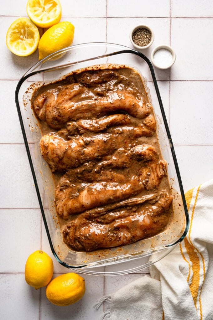 raw chicken in glass dish marinating
