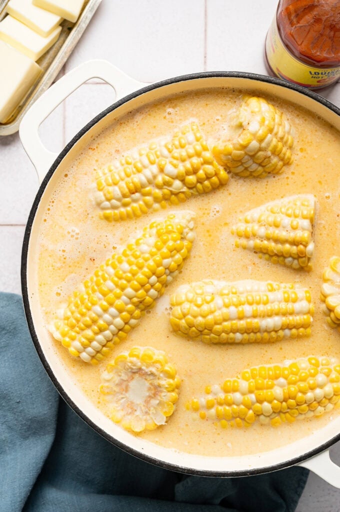 corn on the cob in milk inside of large pot