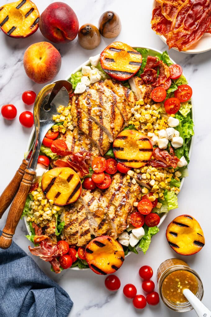 grilled chicken peach salad on platter with utensils