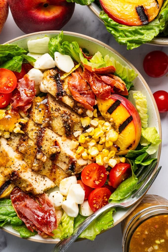 grilled pesto chicken peach salad in bowl
