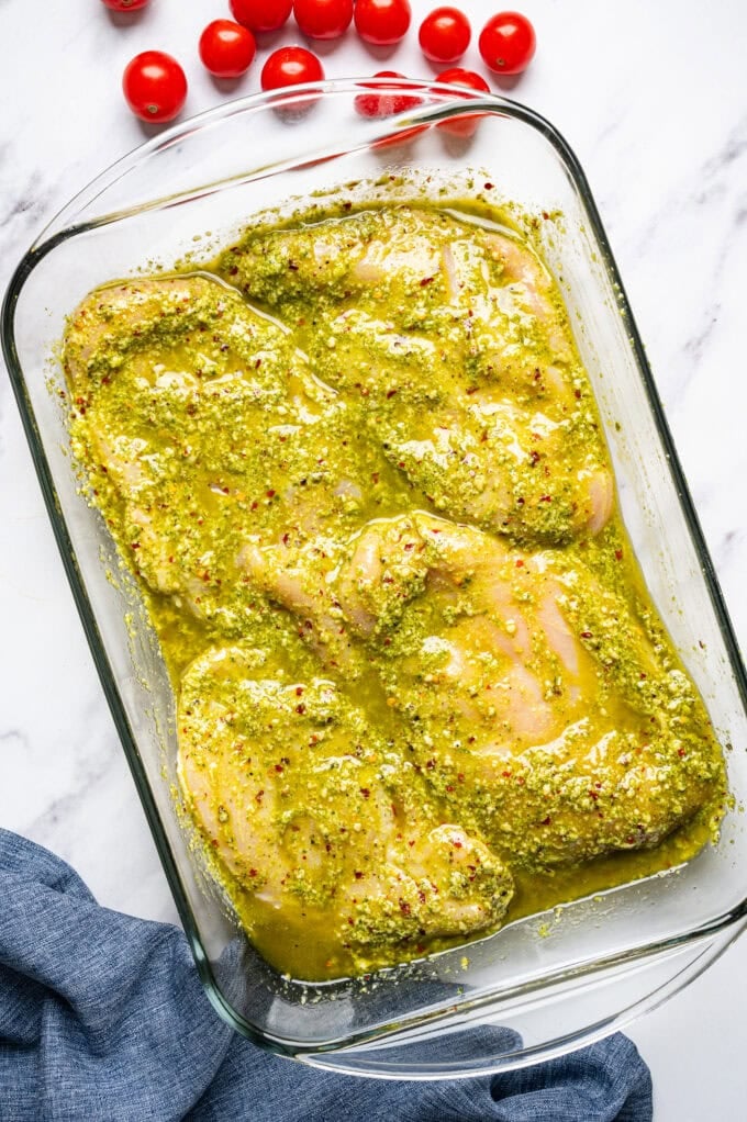 raw marinated chicken breasts in glass bowl