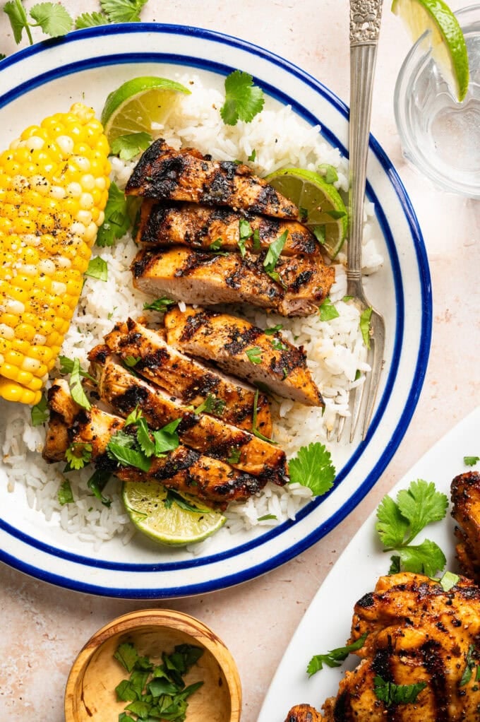 sliced grilled tequila lime marinated chicken on plate with rice and corn