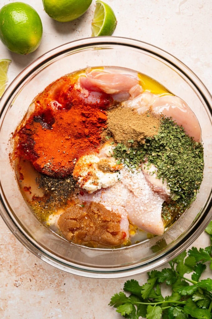 raw chicken with spices in glass bowl