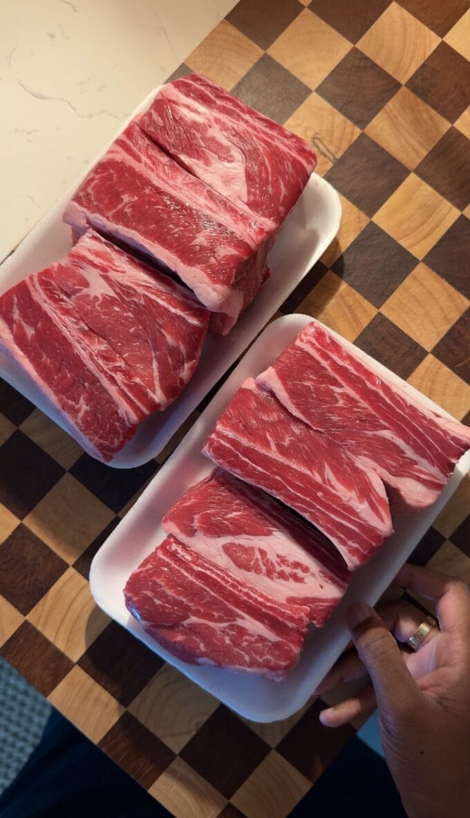 raw beef short ribs on wooden cutting board
