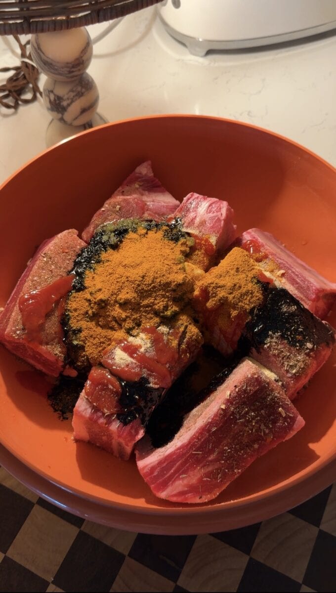 spices on top of beef short ribs in bowl