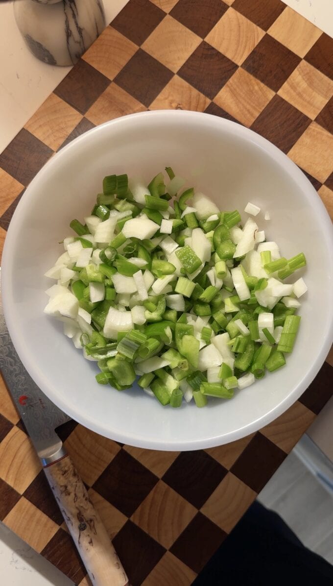 chopped onion, bell pepper, and scallions in bowl
