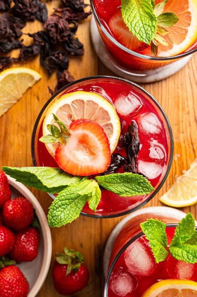 glasses of strawberry hibiscus lemonade with mint and sliced lemon