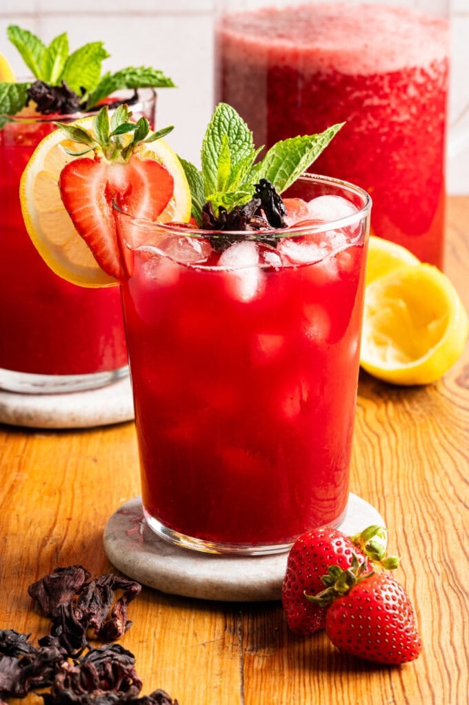 glass of strawberry hibiscus lemonade on white coaster