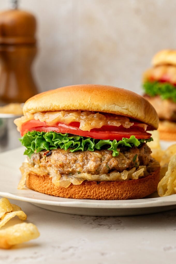 closeup of blue cheese turkey burger with caramelized onion jam on white plate