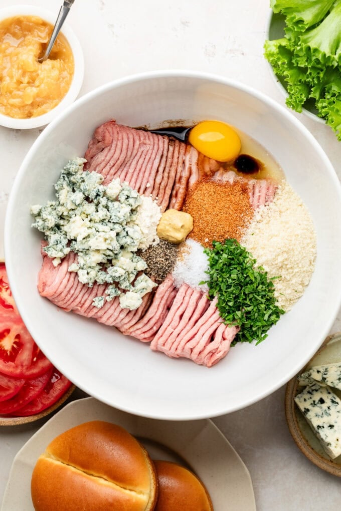 ground meat with blue cheese crumbles and spices in large bowl